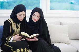 young muslim women reading Quran at home photo