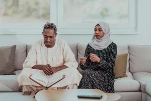 African Muslim couple at home in Ramadan reading Quran holly Islam book. photo