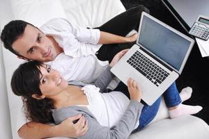 joyful couple relax and work on laptop computer at modern home photo