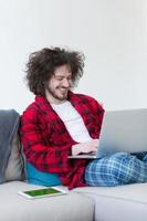 hombre freelance en bata de baño trabajando desde casa foto