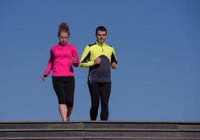 young  couple jogging on steps photo