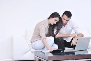 joyful couple relax and work on laptop computer at modern home photo