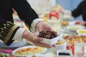 familia musulmana comenzando iftar con fechas durante el ramadán foto