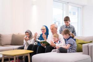 modern muslim grandparents with grandchildren reading Quran photo