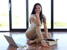 relaxed young woman at home working on laptop computer photo