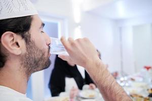 Muslim family having Iftar dinner drinking water to break feast photo