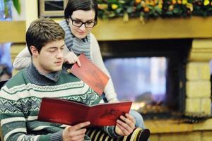 Young romantic couple relax on sofa in front of fireplace at home photo