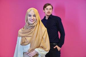 retrato de una feliz pareja musulmana joven que se encuentra aislada en un fondo rosa foto