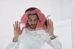 Muslim man doing sujud or sajdah on the glass floor photo