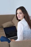 relaxed young woman at home working on laptop computer photo