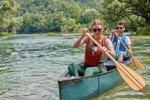 friends are canoeing in a wild river photo