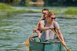 friends are canoeing in a wild river photo