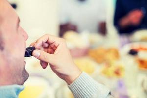 Hombre musulmán moderno comiendo dátiles foto