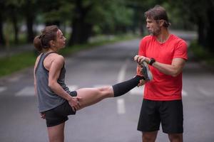 runners team warming up and stretching before morning training photo