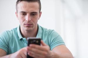 young man using a mobile phone  at home photo