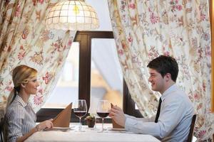 young couple having dinner at a restaurant photo