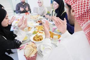 traditional muslim family praying before iftar dinner photo