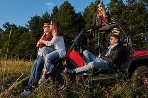 group young happy people enjoying beautiful sunny day while driving a off road buggy car photo