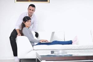 joyful couple relax and work on laptop computer at modern home photo