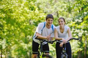 Happy couple riding bicycle outdoors photo