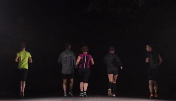equipo de corredores en el entrenamiento nocturno foto