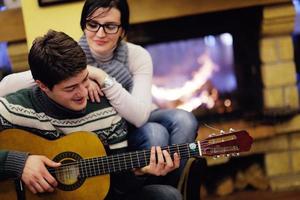 Young romantic couple relax on sofa in front of fireplace at home photo