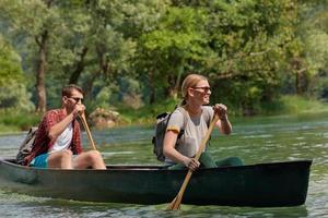 friends are canoeing in a wild river photo