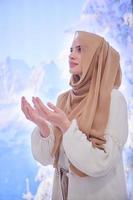 beautiful muslim woman making traditional prayer to God photo