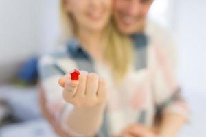 couple showing small red house in hands photo