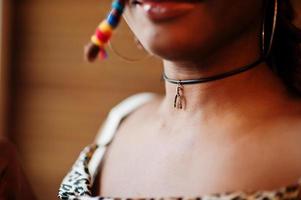 Close up porrtrait of lovely african american woman with dreadlocks in leopard outfit at cafe. Beautiful cool fashionable black young girl indoor. photo