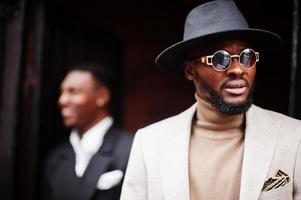 Two fashion black men. Fashionable portrait of african american male models. Wear suit, coat and hat. photo