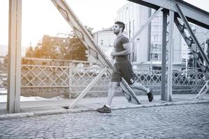 hombre corriendo por el puente en la mañana soleada foto