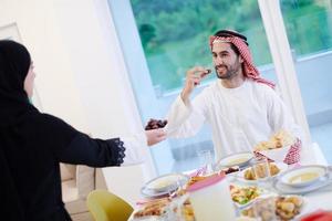 Muslim family having Iftar dinner eating dates to break feast photo