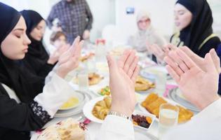 traditional muslim family praying before iftar dinner photo