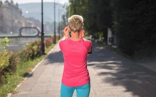 jogging woman setting phone before jogging photo