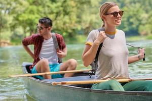 friends are canoeing in a wild river photo