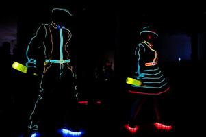 Professional barman and led light show. Silhouette of modern bartender shaking drink at night cocktail bar. photo