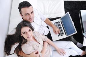 joyful couple relax and work on laptop computer at modern home photo