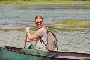 woman adventurous explorer are canoeing in a wild river photo