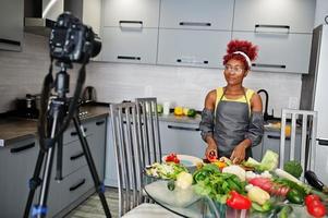 African american woman filming her blog broadcast about healthy food at home kitchen. photo