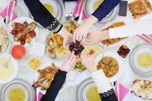 Muslim family having Iftar dinner eating dates to break feast top view photo