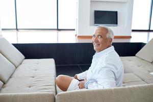 Portrait of senior man relaxing in sofa photo