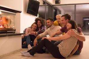 multiethnic couples sitting in front of fireplace photo