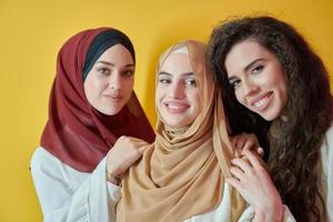 Young muslim women posing on yellow background photo
