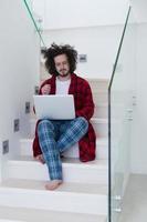 freelancer en bata de baño trabajando desde casa foto