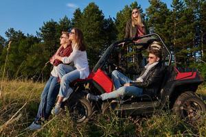 group young happy people enjoying beautiful sunny day while driving a off road buggy car photo