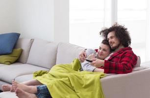 Young couple on the sofa watching television photo