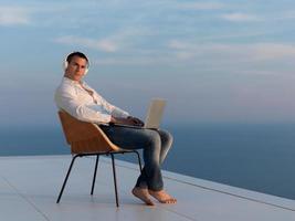 relaxed young man at home on balcony photo