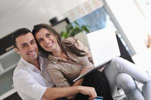 joyful couple relax and work on laptop computer at modern home photo