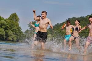 grupo de amigos felices divirtiéndose en el río foto